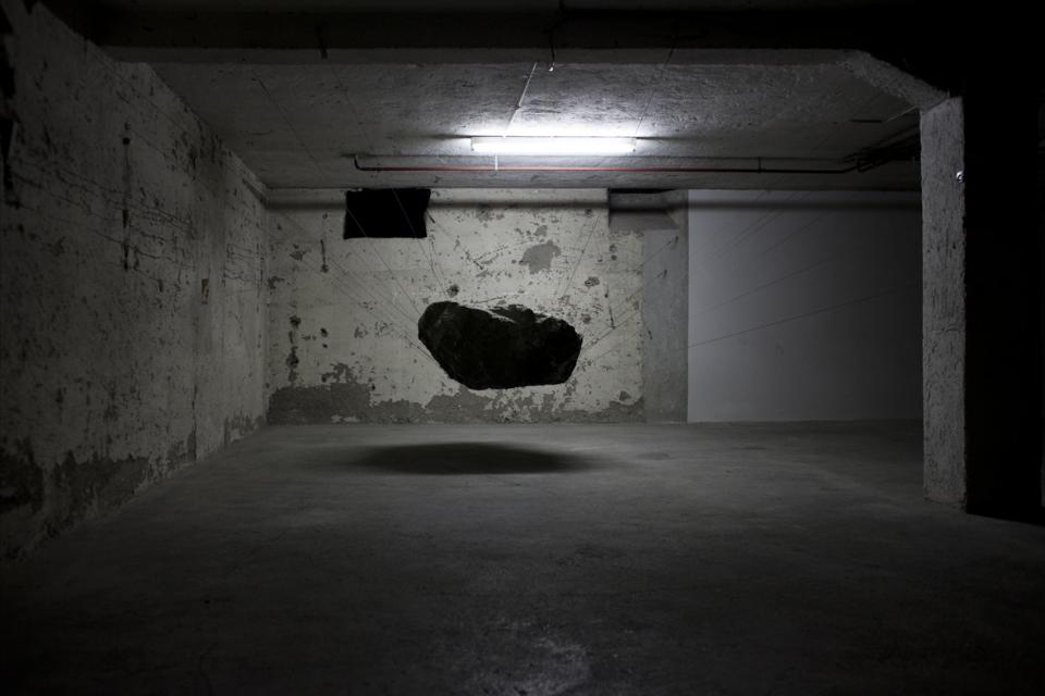 suspended rock on thin wire in cellar