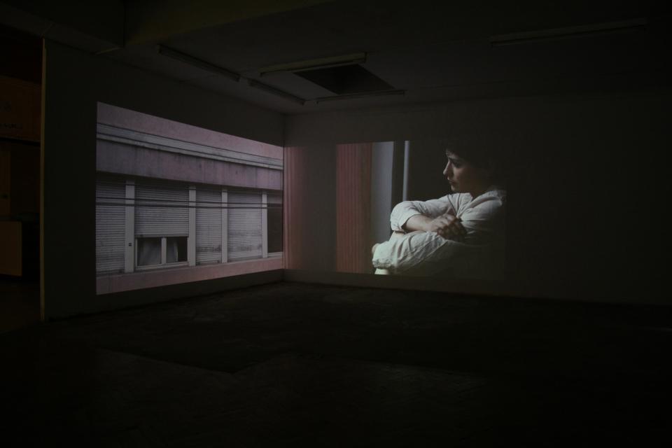two-canal video installation: video of a window, and video of woman looking outside of a window close-up